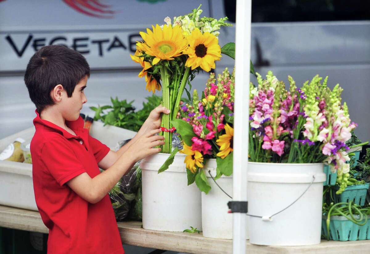 Manuel Lynch, 7, picks out a boquet of sunflowers during Old Greenwich Farmers Market at Living Hope Community Church's parking lot in Old Greenwich, Conn., on Wednesday June 22, 2022. The market is held from 2:30 to 6 p.m. Wednesdays at 38 West End Ave. in Old Greenwich. The market is held rain or shine. For more information email info@oldgreenwichfarmersmarket.com
