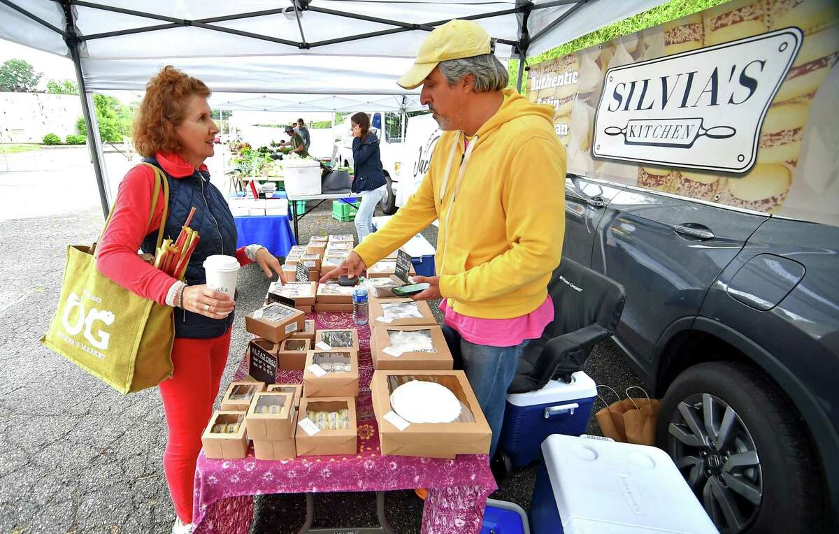 Guillermo MacLean, with Sylvia's Kitchen, helps customer Susan Tetzlaff during Old Greenwich Farmers Market at Living Hope Community Church's parking lot in Old Greenwich, Conn., on Wednesday June 22, 2022. The market is held from 2:30 to 6 p.m. Wednesdays at 38 West End Ave. in Old Greenwich. The market is held rain or shine. For more information email info@oldgreenwichfarmersmarket.com