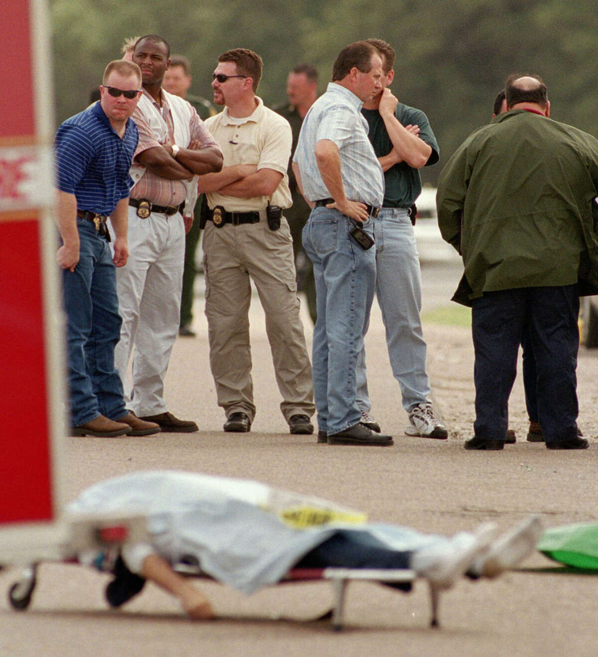 5/14/2003--A body lies draped at a scene where 16 people were found dead early Wednesday in and around the trailer of an 18-wheeler truck left at a truck stop near Victoria, TX. Sheriff's deputies found the bodies about 2 a.m. when they answered a reported disturbance inside a trailer at the Speedy Stop truck stop, six miles south of Victoria, TX on US 77 at Fleming Prarie Rd. Photo by Steve Ueckert / Chronicle