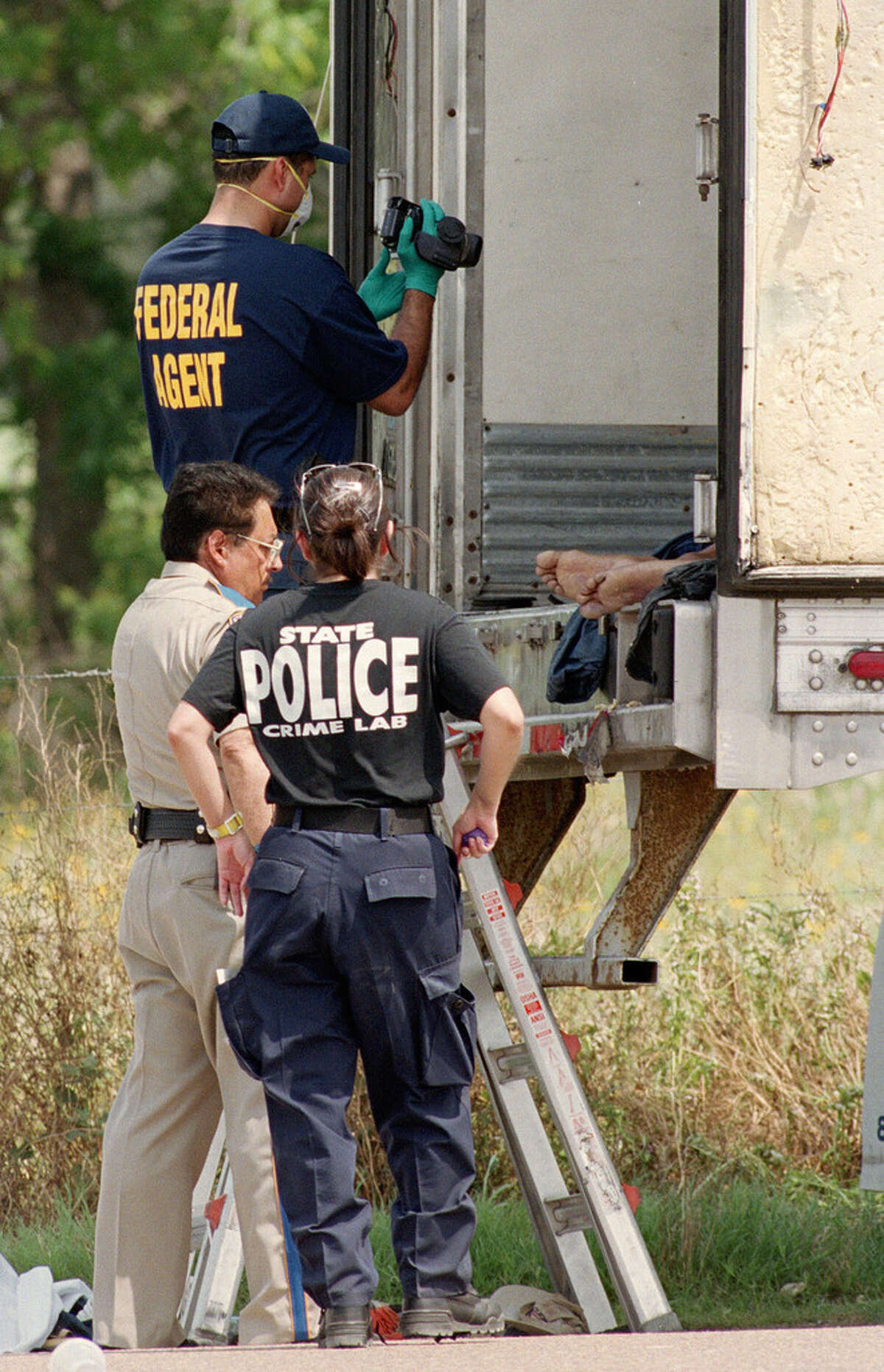 5/14/2003--Investigators photograph the scene inside and around a truck trailer where 16 people were found dead early Wednesday at a truck stop near Victoria, TX. Sheriff's deputies found the bodies about 2 a.m. when they answered a reported disturbance inside a trailer at the Speedy Stop truck stop, six miles south of Victoria, TX on US 77 at Fleming Prarie Rd. Photo by Steve Ueckert / Chronicle