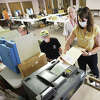 John Badman|The Telegraph A woman casts her vote in Alton Precinct 6 Tuesday at Messiah Lutheran Church on Milton Road as election judge John Siampos, center, supervises. Voter turnout was fairly light early Tuesday.