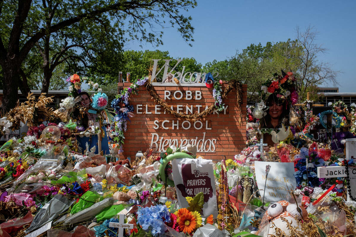 The Robb Elementary School sign is seen covered in flowers and gifts on June 17, 2022 in Uvalde, Texas.(Photo by Brandon Bell/Getty Images)