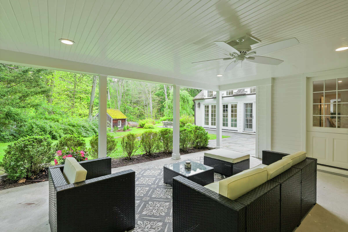 This backcountry home is situated on 4.11 acres, with landscaping personally designed by the homeowner, an avid gardener. The house is appended with several outdoor living, dining and recreational areas, including this covered porch.