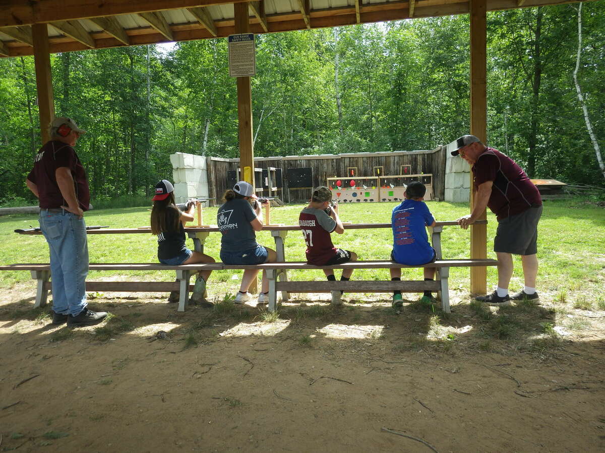 Jay Tuckey of Caro (left) and Arlin Herford of Cass City instructing kids on the Cass City Gun Club's .22 rifle range, which featured fun targets.