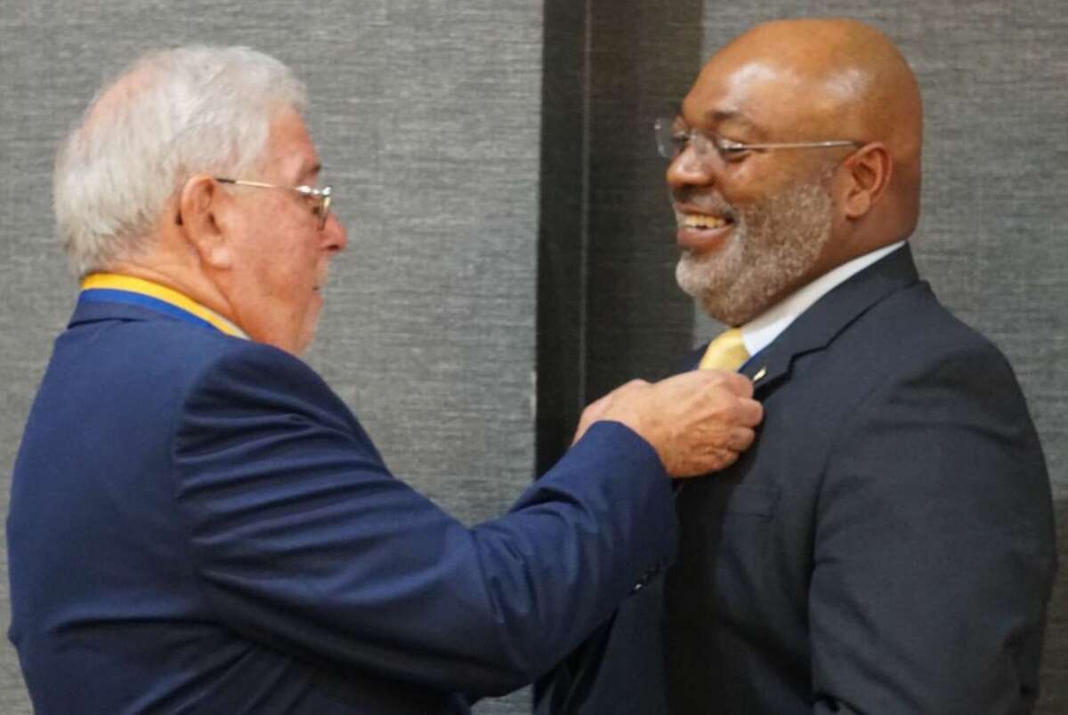 Retiring Alton-Godfrey Rotary Club President  Steve Schwartz, left, passes the presidency to Antione E. Williams. The club will begin its 102nd year of service to Alton and Godfrey on Friday. 
