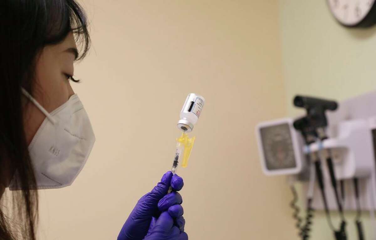 Medical assistant Yinhua Cui prepares a COVID-19 booster for a patient at Chinese Hospital  in San Francisco, Calif.