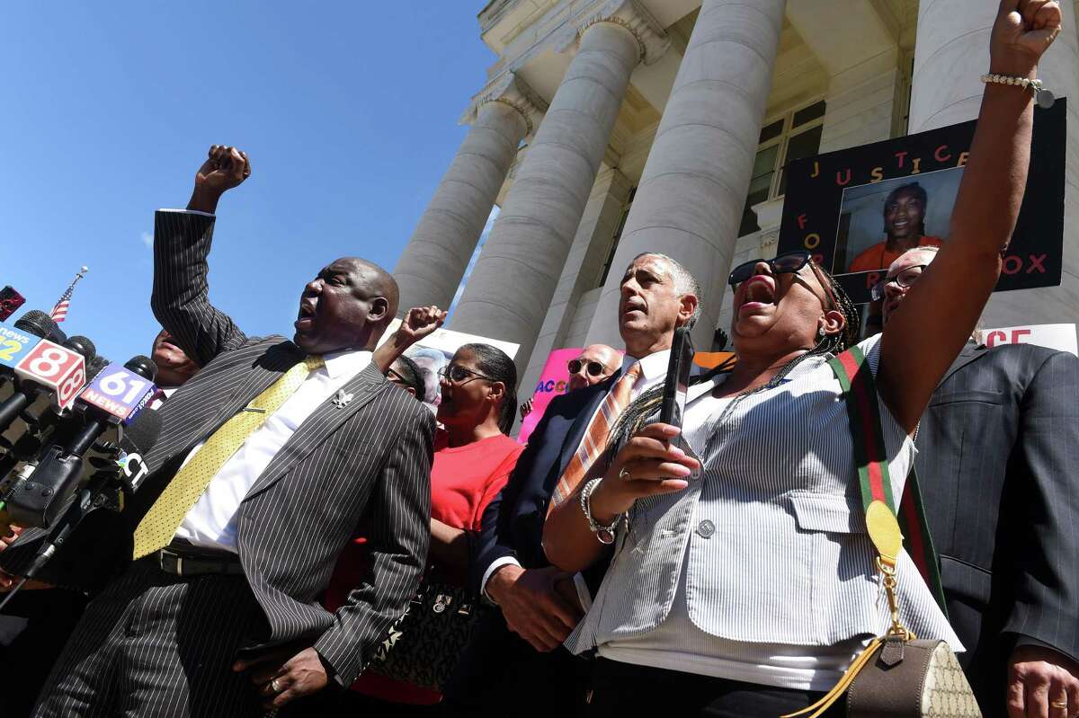 Civil rights attorney Benjamin Crump, left, is joined by Dori Dumas, right, president of the Greater New Haven NAACP, along with the family of Richard “Randy” Cox Jr. and others on the steps of Superior Court in New Haven Tuesday for a news conference concerning the injuries sustained by Cox while being transported in a New Haven police van.