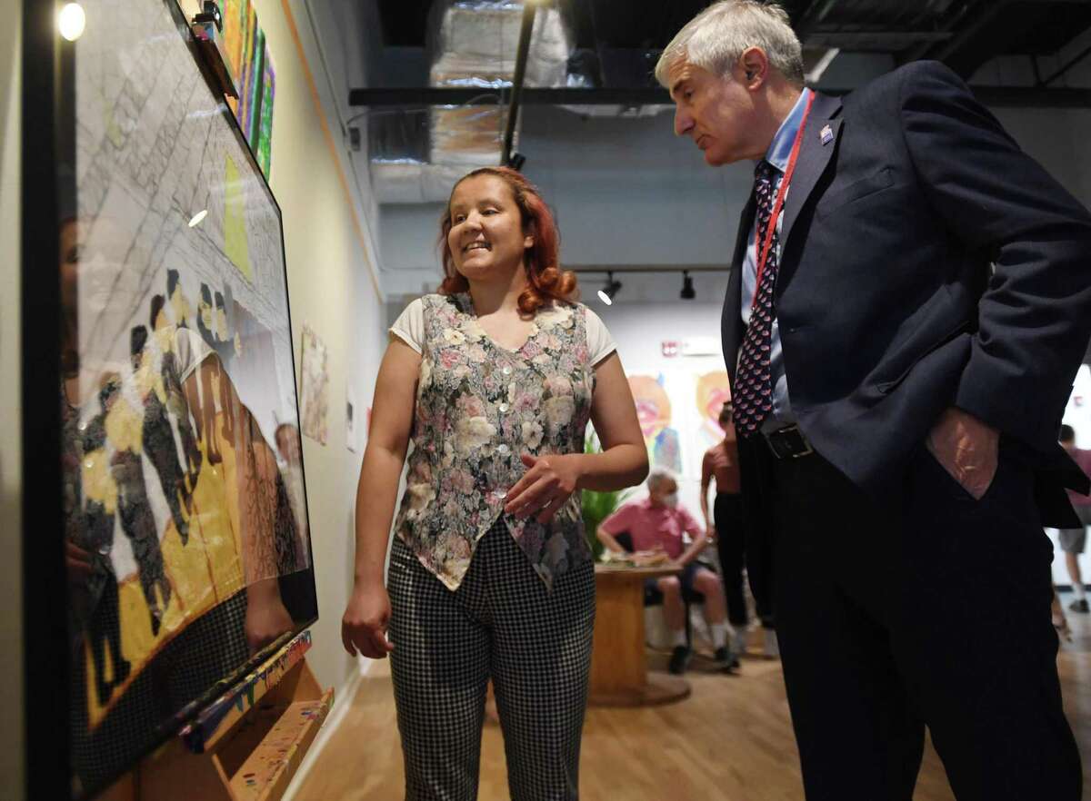 Kennedy Center artist Christina Bevans, of Stratford, donates her artwork, commemorating victims of the Pearl Harbor attack, to Homes for the Brave CEO Vincent Santilli, at the Kennedy Center Arts Co-op in Bridgeport, Conn. on Tuesday, June 28, 2022.