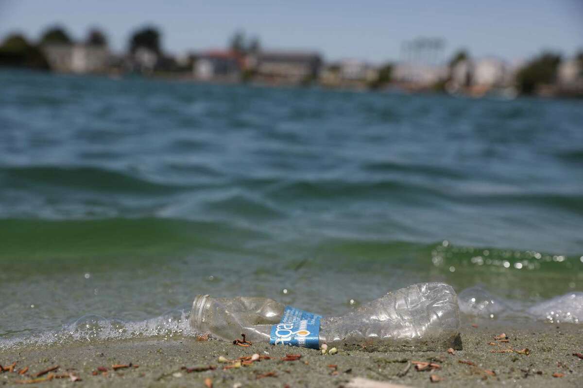 A plastic bottle sits at the water’s edge at Erckenbrack Park Beach in Foster City. A major new law in California seeks to reduce the amount of plastic that residents use.