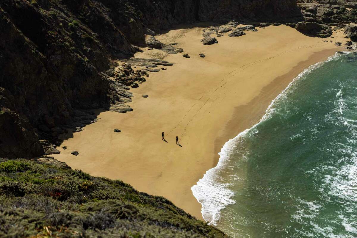 People at Gray Whale Cove State Beach. Two people were killed in separate incidents when their vehicles went off the roadway at Gray Whale Cove in 2020.