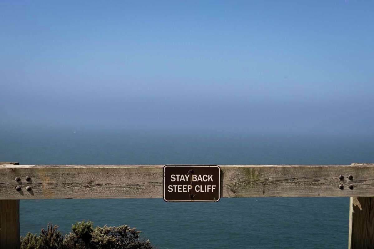 Signs at the Devil’s Slide Trail warn hikers to stay off the cliffs.