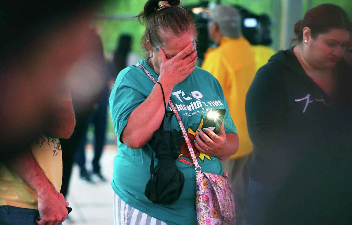 Maria de la Cruz places her hand to her face in prayer as people attend a candlelight vigil at Pearsall Park on Tuesday, June 28, 2022 to pay tribute to the 50 lives lost and to survivors of human smuggling, as well as all loved ones impacted by Monday’s horrific discovery in an abandoned semi-truck trailer.