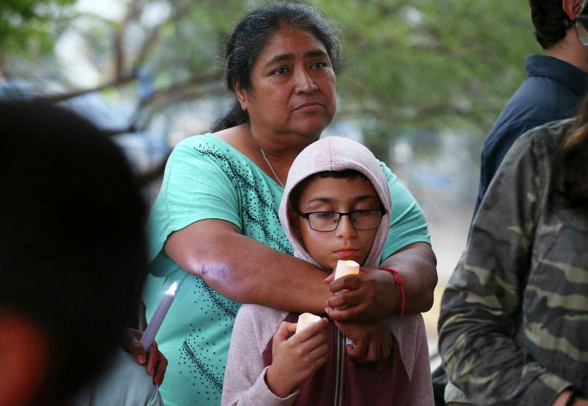 Maria Gallardo and her adopted son, Andrew Martinez, hold candles as they join others at a candlelight vigil at Pearsall Park on Tuesday, June 28, 2022 to pay tribute to the 50 lives lost and to survivors of human smuggling, as well as all loved ones impacted by Monday’s horrific discovery in an abandoned semi-truck trailer.