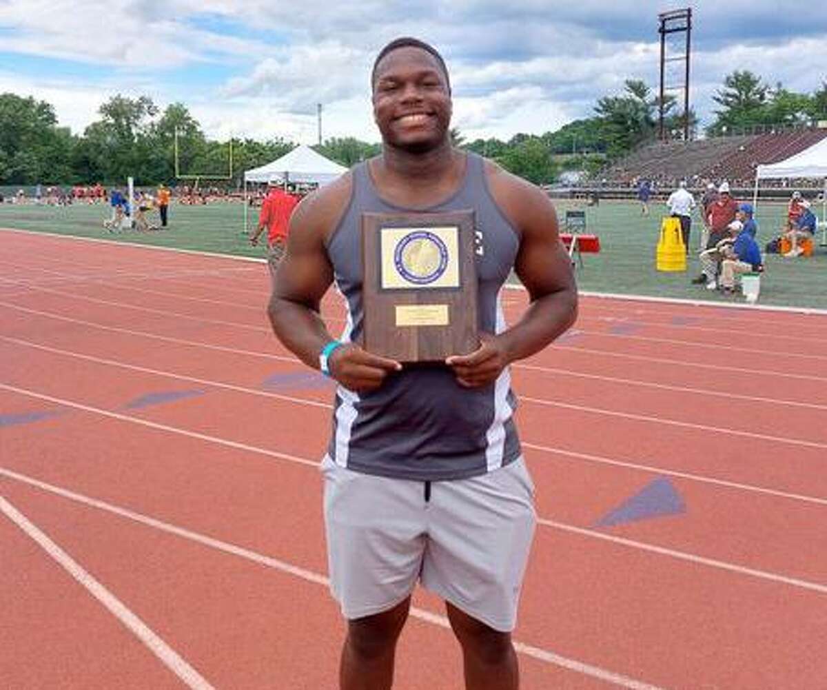 Gary Moore Jr. of Hillhouse holds the first-place plaque for winning the discus at the New England track meet.