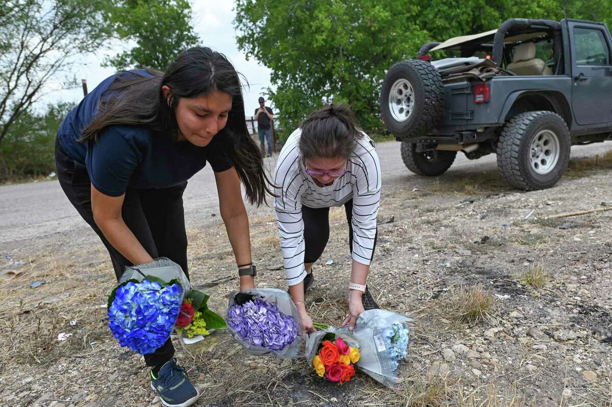 Delilah Hernandez, left, and her mother, Marissa, lay flowers on Tuesday, June 28, 2022, at the site where 50 immigrants died as a result of heat in a trailer on Monday.