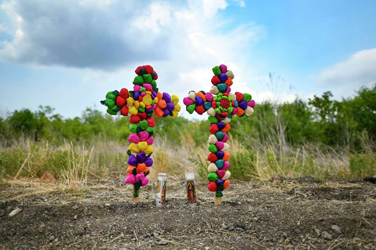 Crosses left by South San Antonio residents Debra Ponce and Angelita Olvera stand at the site where a sweltering tractor-trailer full of migrants was discovered on the Southwest Side.