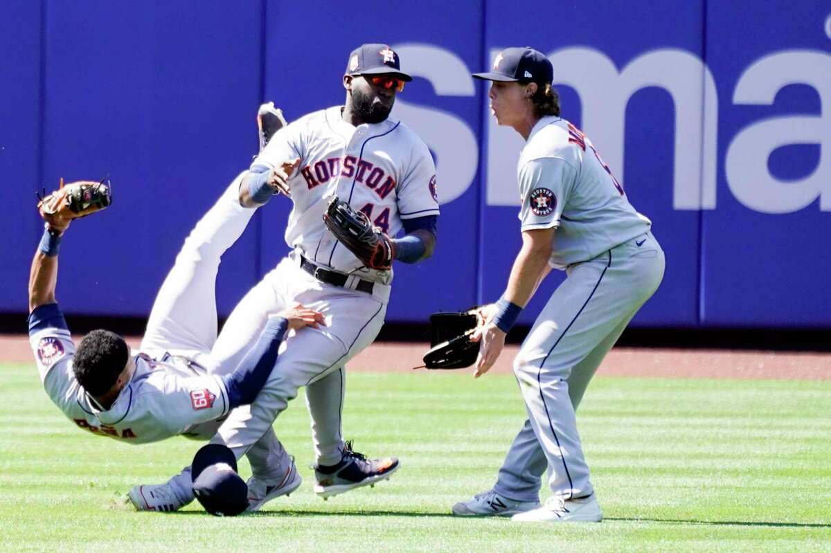 Astros shortstop Jeremy Peña, left, takes a tumble after colliding with teammate Yordan Alvarez (44) during Wednesday's game against the Mets in New York.