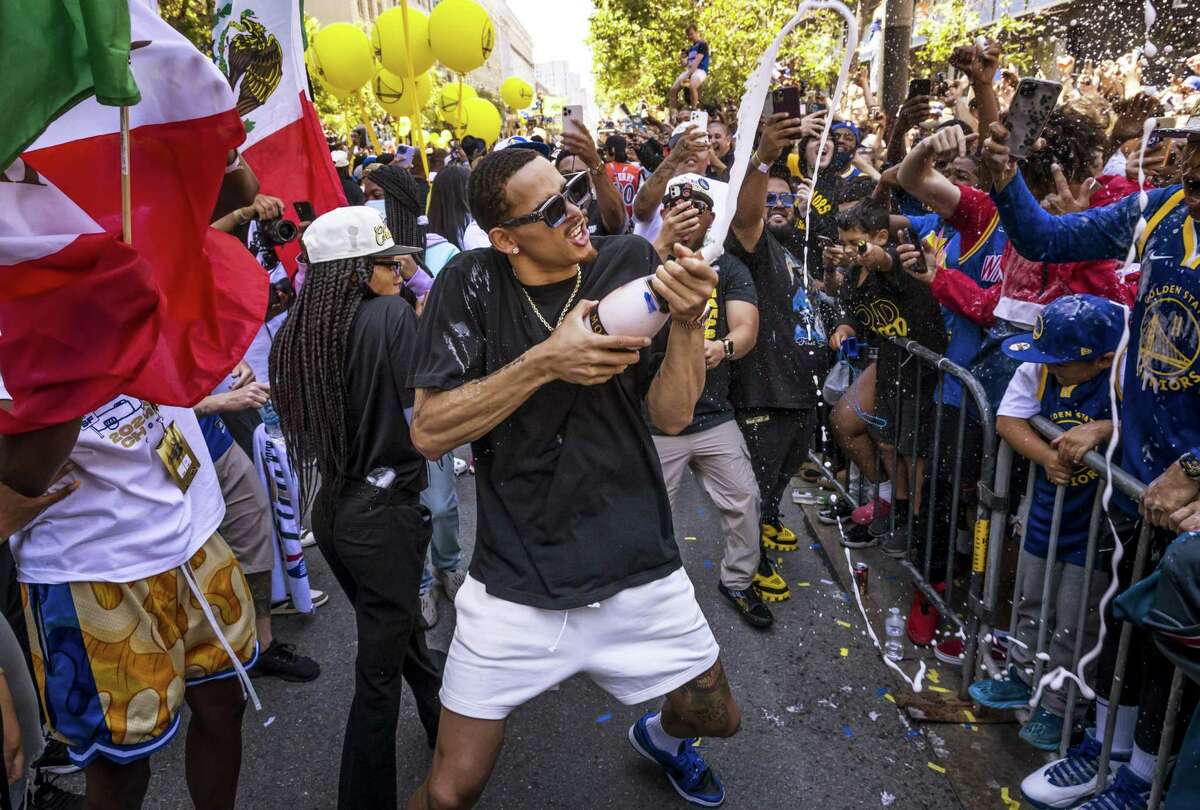 Juan Toscano Anderson sprays the crowd with champagne as the Golden State Warriors celebrated their 2022 NBA Champsionship with a parade down Market Street in San Francisco, Calif., on Monday, June 20, 2022.