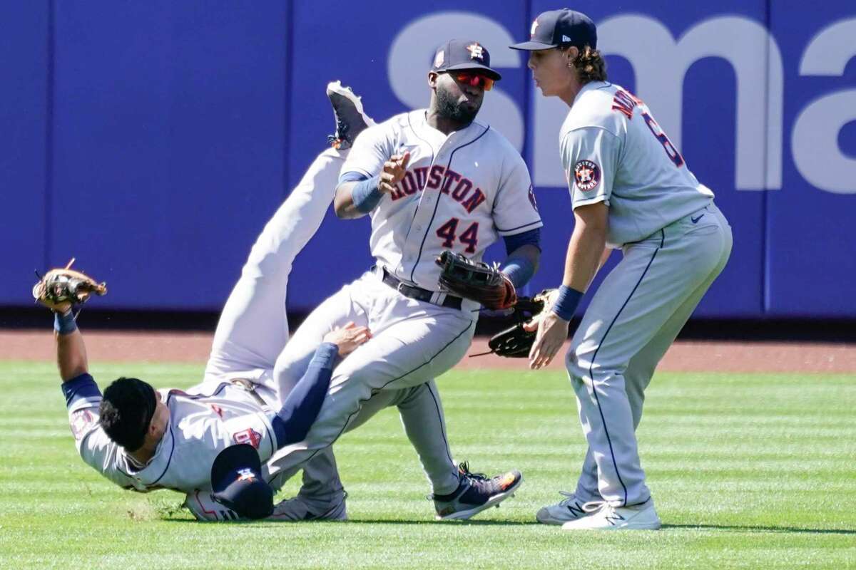 Houston Astros' Jake Meyers (6) watches as Jeremy Pena, left, and Yordan Alvarez (44) fall to the ground after colliding catching a fly ball by New York Mets' Dominic Smith during the eighth inning of a baseball game, Wednesday, June 29, 2022, in New York. (AP Photo/Mary Altaffer)