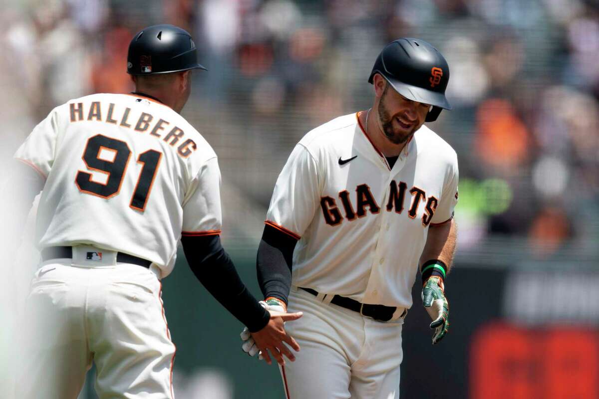 San Francisco Giants' Evan Longoria gets a congratulatory handshake from third base coach Mark Hallberg (91) after hitting a solo home run against the Detroit Tigers during the first inning of a baseball game, Wednesday, June 29, 2022, in San Francisco. (AP Photo/D. Ross Cameron)