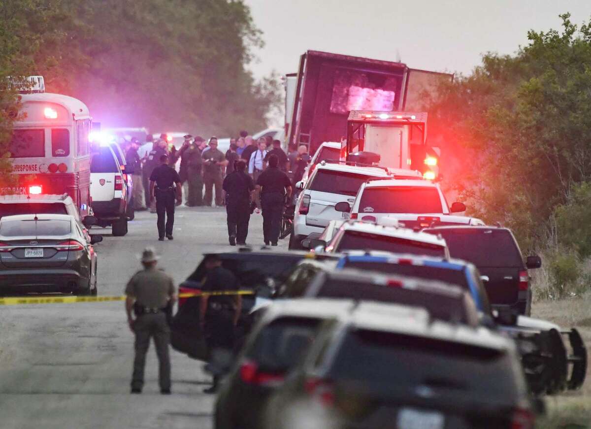 Emergency personnel survey the scene where an abandoned tractor trailer was discovered with dozens of dead migrants inside on June 27, 2022. Fifty-three migrants died after being trapped in the sweltering tractor trailer and 11 more were injured.