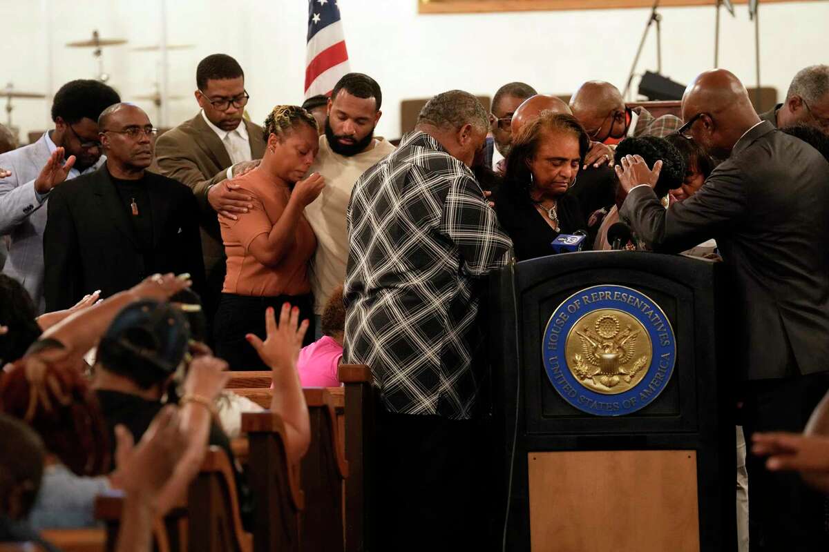Attendees at East Bethel Missionary Baptist Church pray for the family of the Rev. Ronald K. Mouton Sr. on Wednesday.