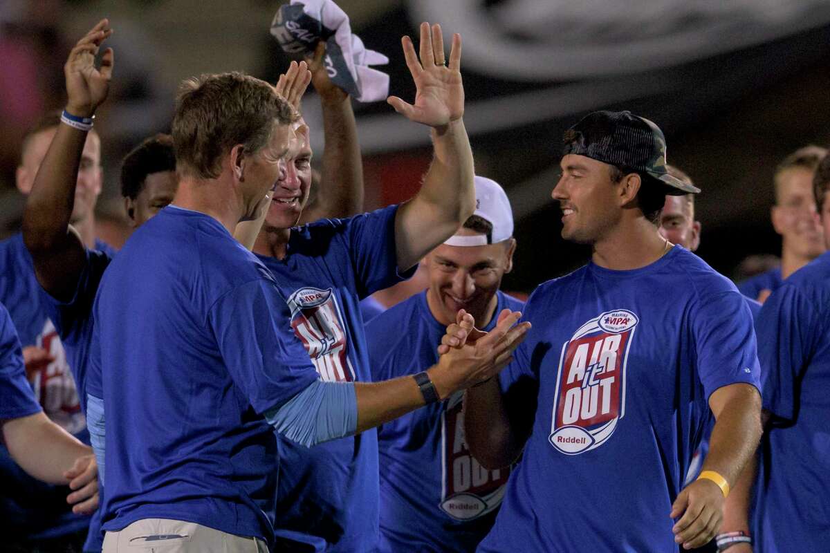 Super Bowl-winning quarterbacks Eli Manning, left, and Peyton Manning, second from left, hail Clayton Tune, right, after the University of Houston QB won the Air it Out throwing event at the Manning Passing Academy on the Nicholls State University campus in Thibodaux, La.