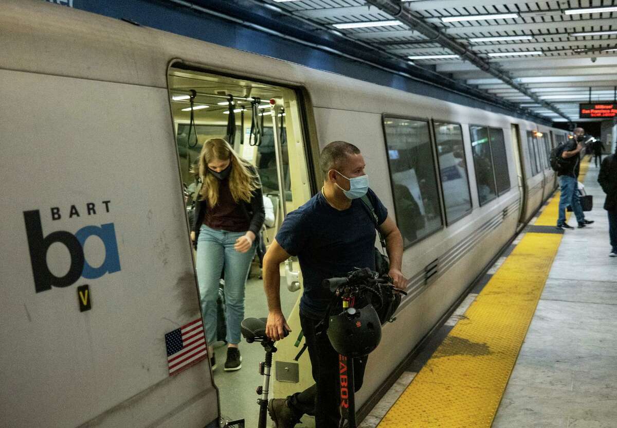 Passengers wearing masks leave a BART train in San Francisco on Thursday, June 23, 2022.
