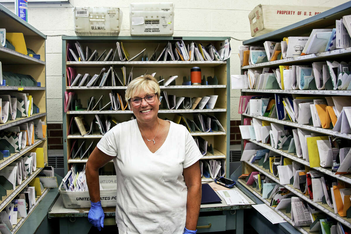 Margot Gillespie poses for a picture at her station at the U.S. Post Office in Manistee on Thursday. Gillespie was set to retire Thursday after 27 years of service to the postal service