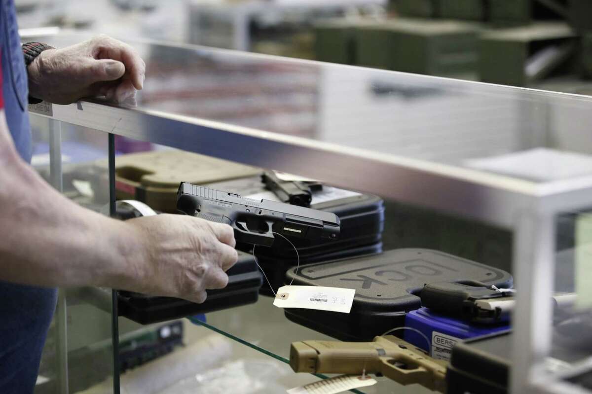 A salesperson takes a Glock handgun out of a case at a store in Orem, Utah, on March 25, 2021.