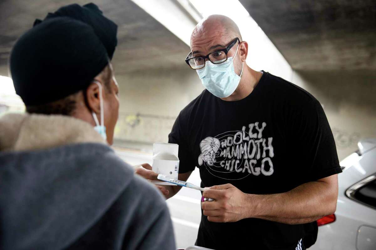 Cory Dodge, a volunteer with West Oakland Punks With Lunch, explains how to administer naloxone at one of the organizations pop-up sites in Oakland on June 12.