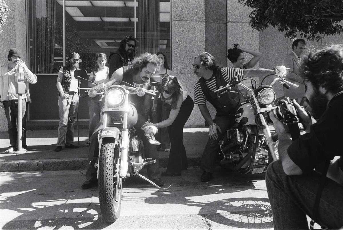 Ralph “Sonny” Barger of the Hells Angels wipes oil off his Harley-Davidson motorcycle before he taking off from the federal court building.