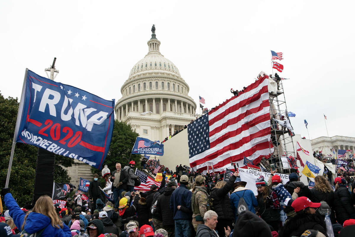 Rioters stand outside the U.S. Capitol in Washington, on Jan. 6, 2021. A new poll shows that about half of Americans say former President Donald Trump should be charged with a crime for his role in what happened on Jan. 6. The Associated Press-NORC Center for Public Affairs Research poll found that 48% of U.S. adults believe Trump should be held accountable for what happened during the deadly Capitol attack.(AP Photo/Jose Luis Magana, File)