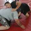 Jacksonville wrestler Oliver Cooley works on a move during a camp earlier this summer.