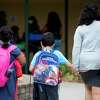 Students and their parents arrive for the first day of school at Howard Elementary School in Oakland, Calif. Monday, August 9, 2021. Some Oakland Unified School District teachers and staff didn’t get paid on time due to what the school district characterized as a payroll error.