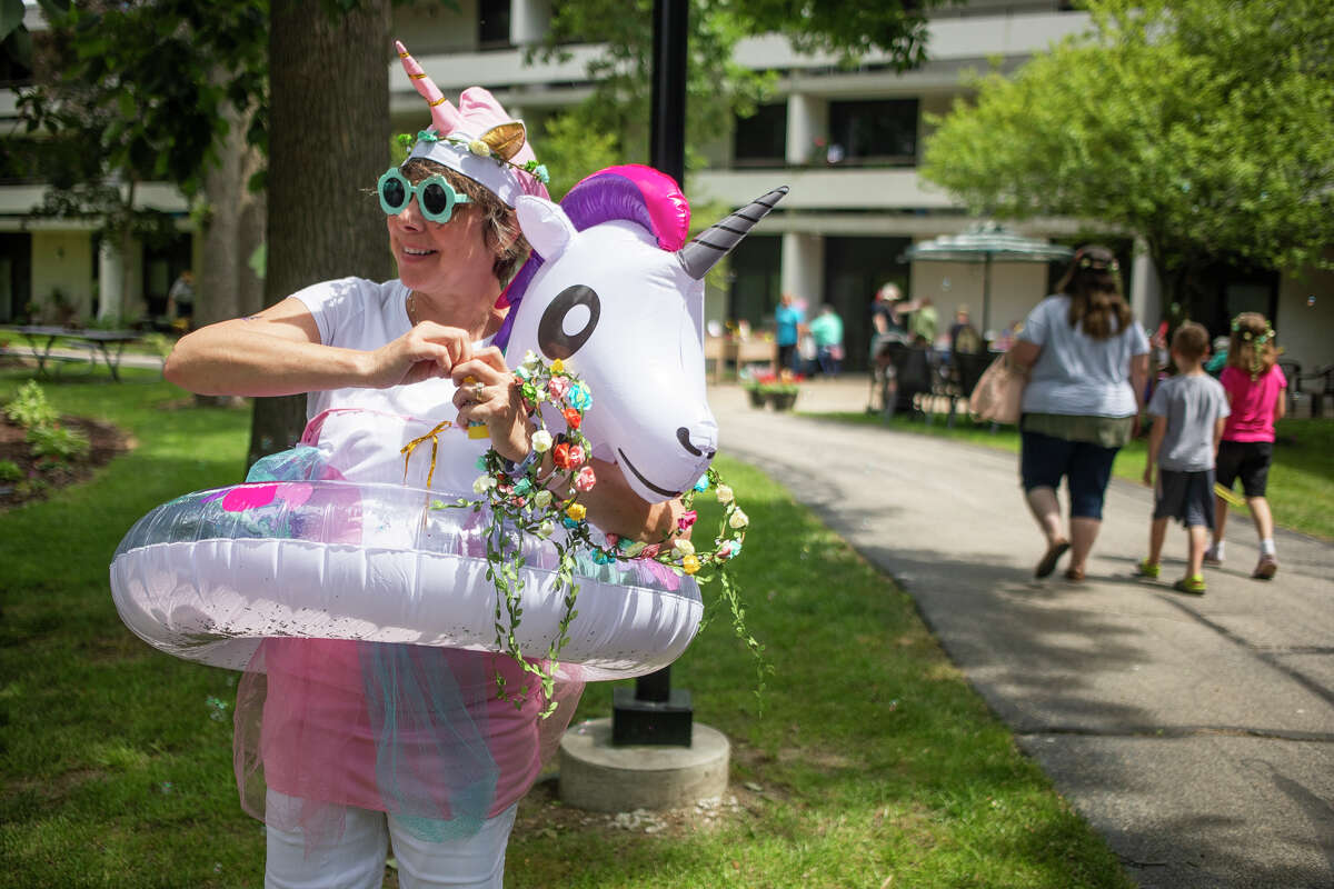 Trisha Harner wears a unicorn-themed outfit as community members join residents of Washington Woods senior housing for a Fairy Garden celebration Thursday, June 30, 2022 in Midland.