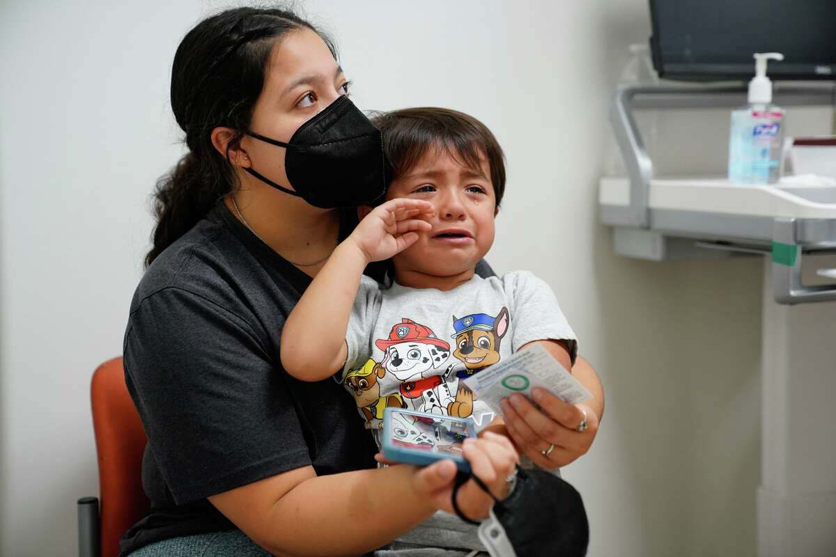 Ezra Von Allmen recovers with a sticker during a vaccination clinic on Thursday sponsored by University Health at its Robert B. Green campus downtown. With him is his mother, Lauren Von Allmen.