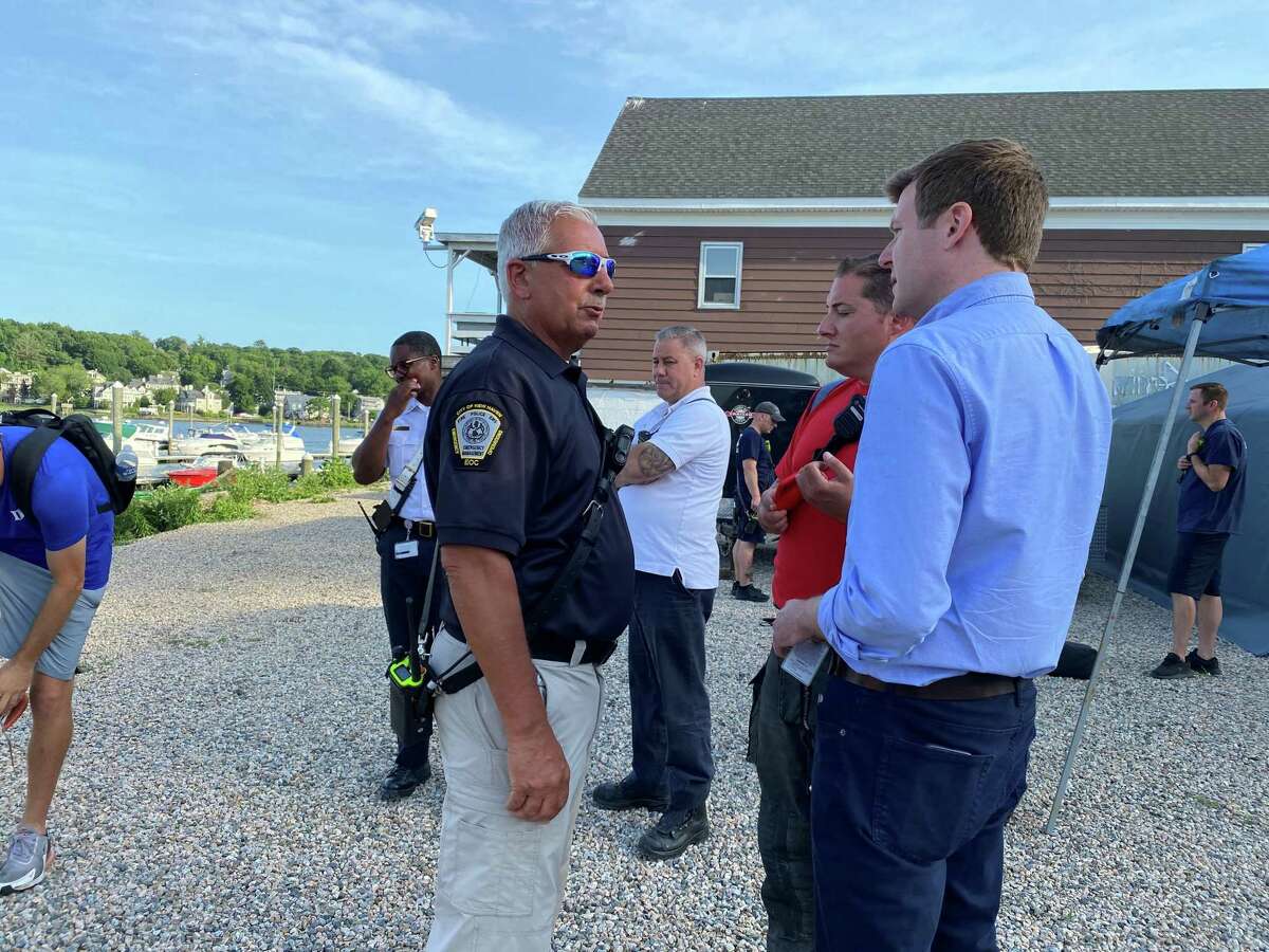 New Haven Emergency Operations Director Rick Fontana, left, with Tweed New Haven Airport Executive Director Sean Scanlon, right, speaking near Quinnipiac River where a couple crashed a plane. The couple was heading to Massachusetts from New Jersey.