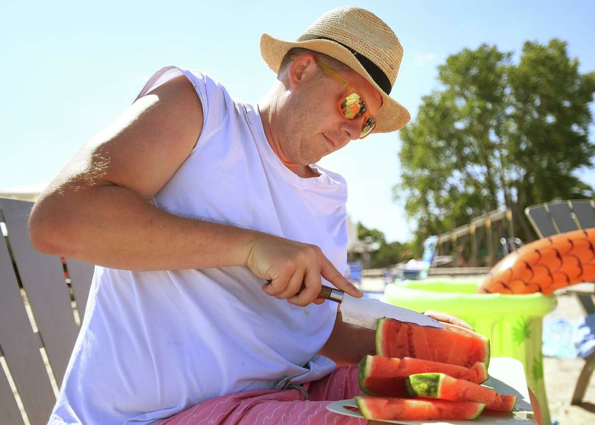 Chris Corbin, of Westport, slices watermelon at the annual fireworks event Thursday.