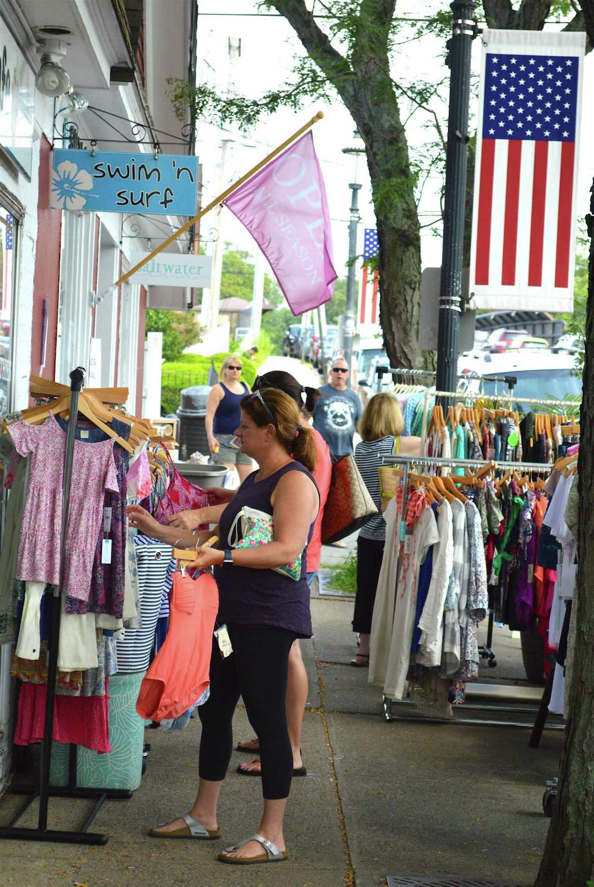 Ali Mitchell of Fairfield takes a look at some clothes on Unquowa Road during a previous Fairfield Sidewalk Sale and Street Fair in a recent year. The Town of Fairfield is having its annual Sidewalk Sale and Street Fair July 16, from 10 a.m. to 4 p.m., rain or shine in the Fairfield Center part of the town.