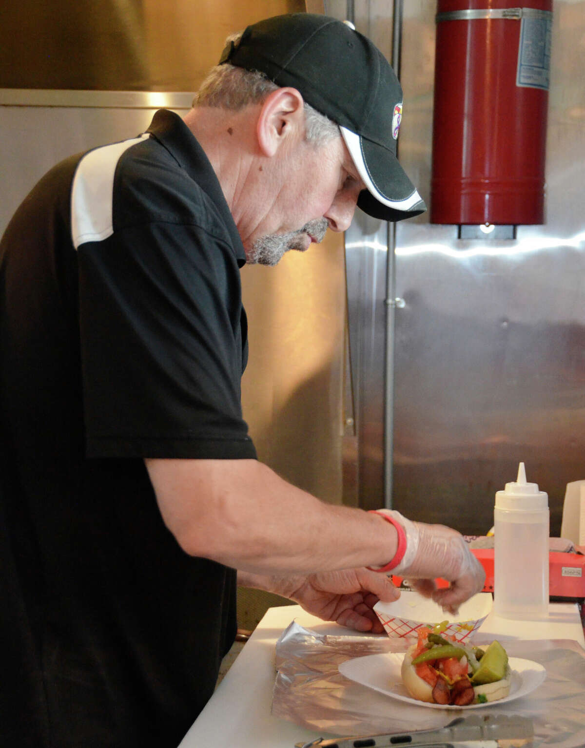 Jeff 'Jake' Russell prepares one of his classic hot dogs at Jake's Diggity Dogs in downtown Milford, Conn.