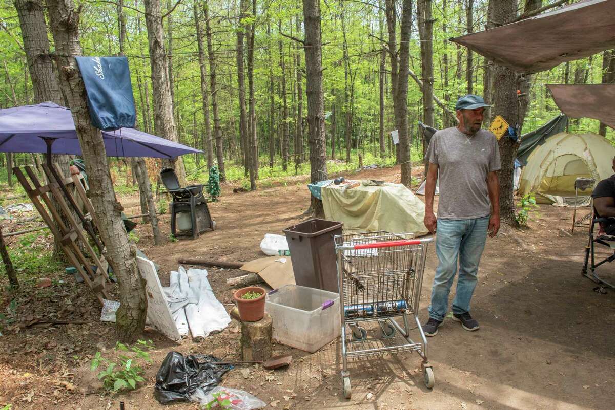 Ralph Weddle talks to a neighbor in a homeless encampment where he lives near the Amtrak Train Station on Friday, June 1, 2022 in Saratoga Springs, N.Y. He and others are moving the encampment to another location because this land is being purchased.