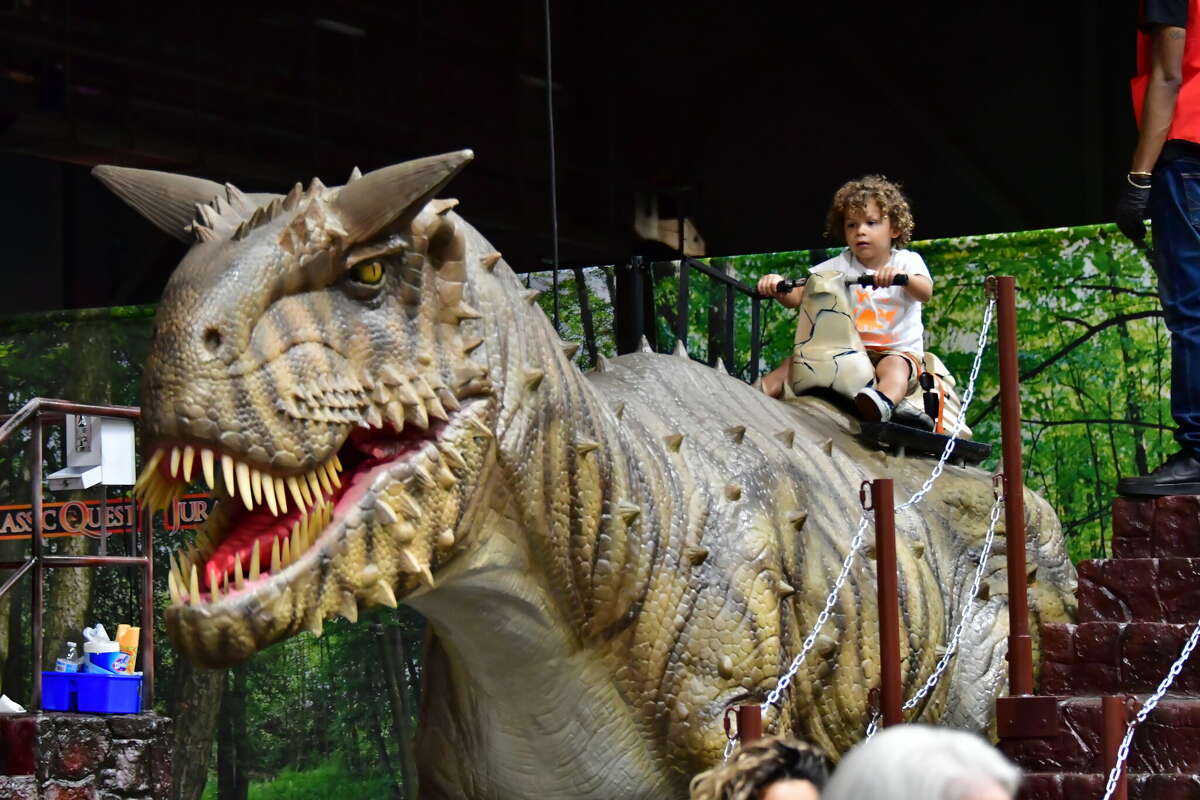 A child rides a carnotaurus.