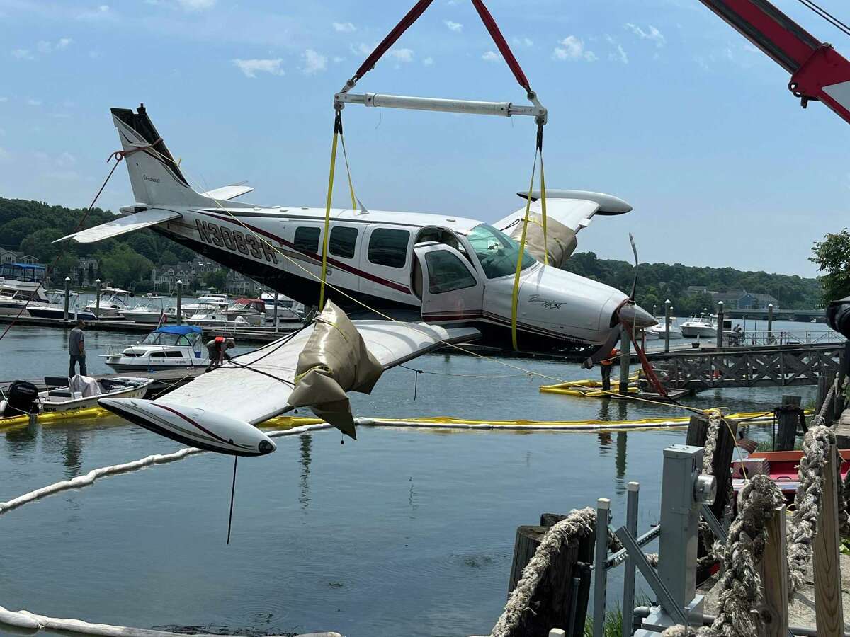 A plane that landed in the Quinnipiac River Thursday is lifted from the water Friday afternoon.