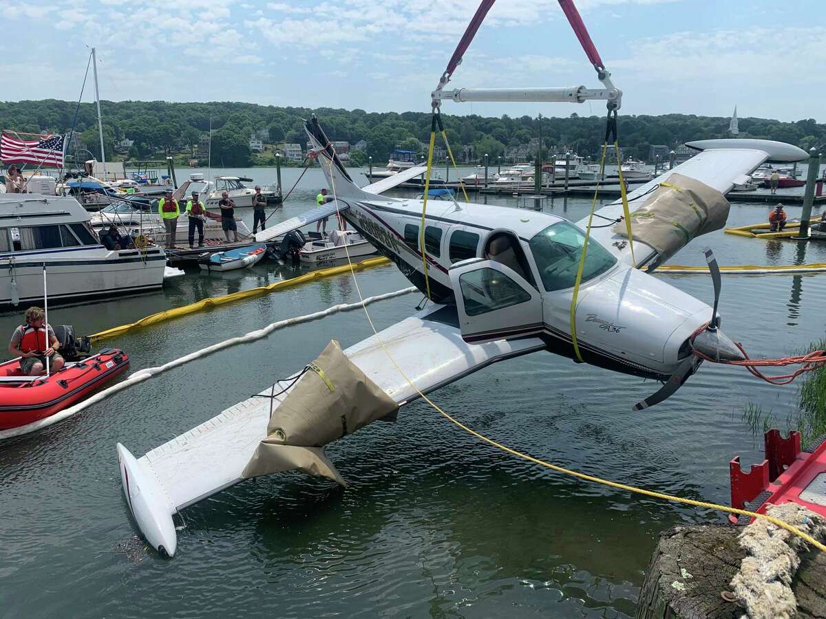 A plane that landed in the Quinnipiac River Thursday is lifted from the water Friday afternoon.