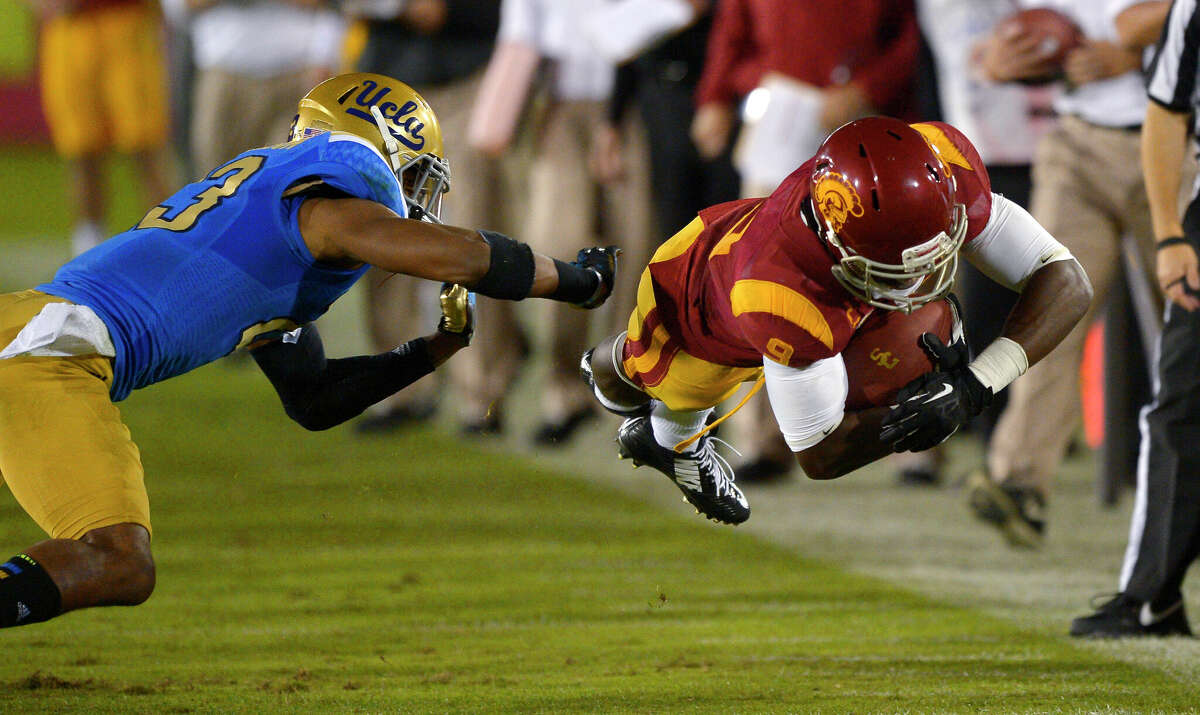 Southern California wide receiver Marqise Lee, right, dives for extra yards as UCLA cornerback Anthony Jefferson defends during the second half of an NCAA college football game, Saturday, Nov. 30, 2013, in Los Angeles. UCLA won 35-14.