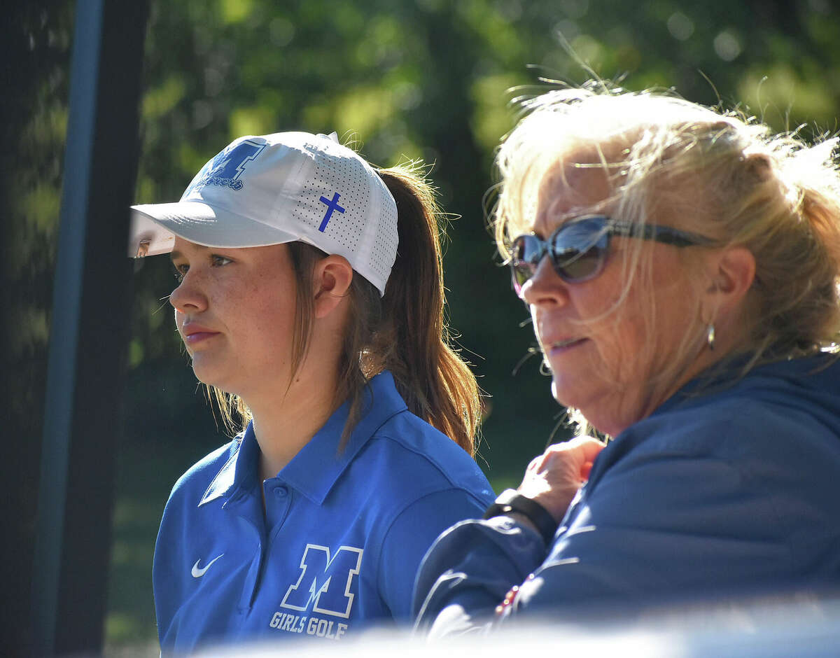 Marquette coach Deb Walsh and senior Clancy Maag watch play at the Gary Bair Invite last season at Oak Brook in Edwardsville.