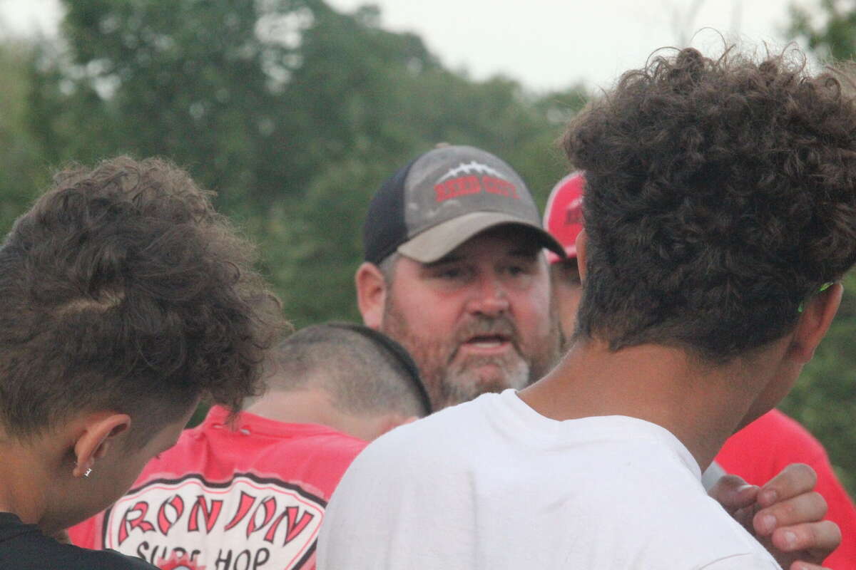 Reed City coach Scott Shankel (center) talks with his players after Thursday's passing camp.