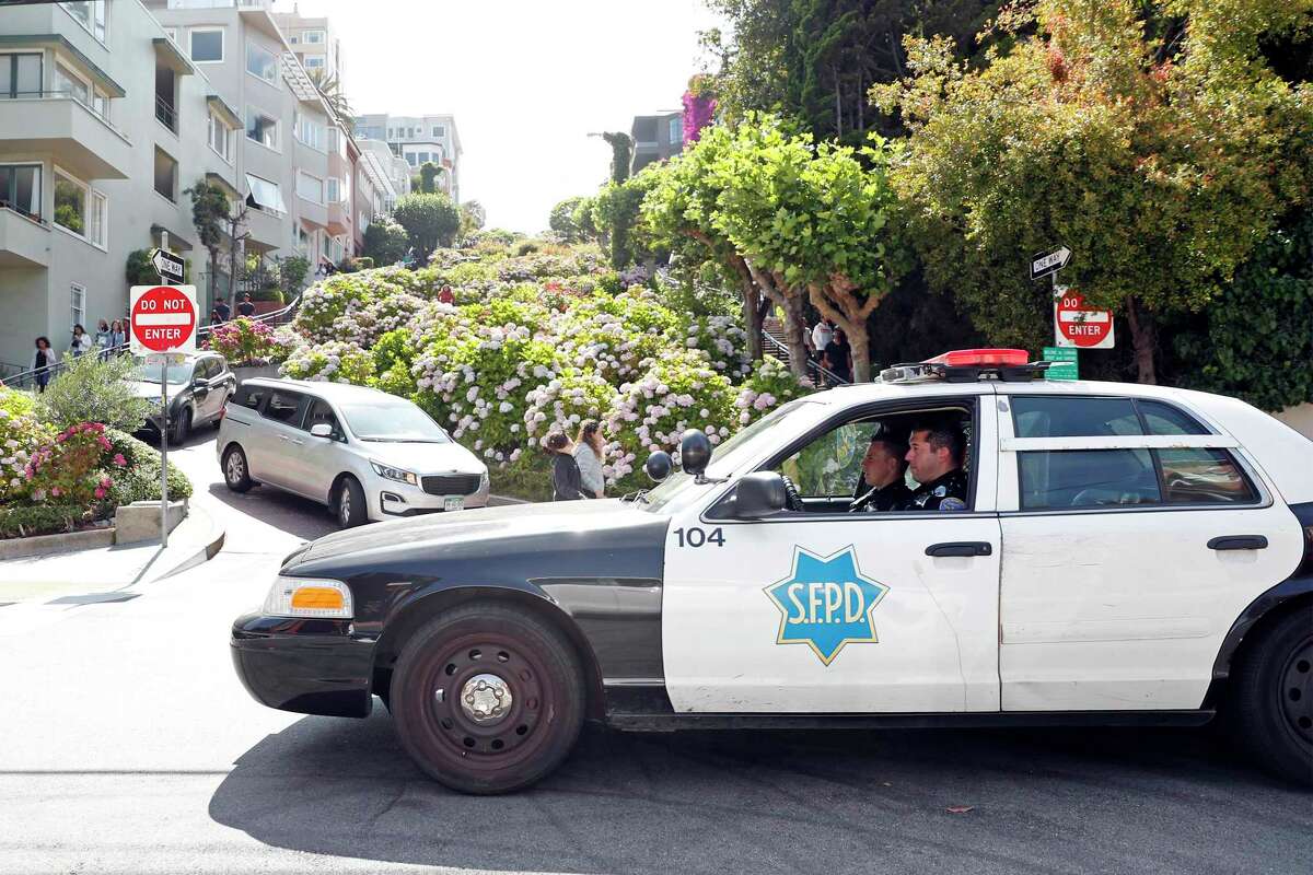 An SFPD squad car patrols at the bottom of the crooked portion of Lombard Street in San Francisco.