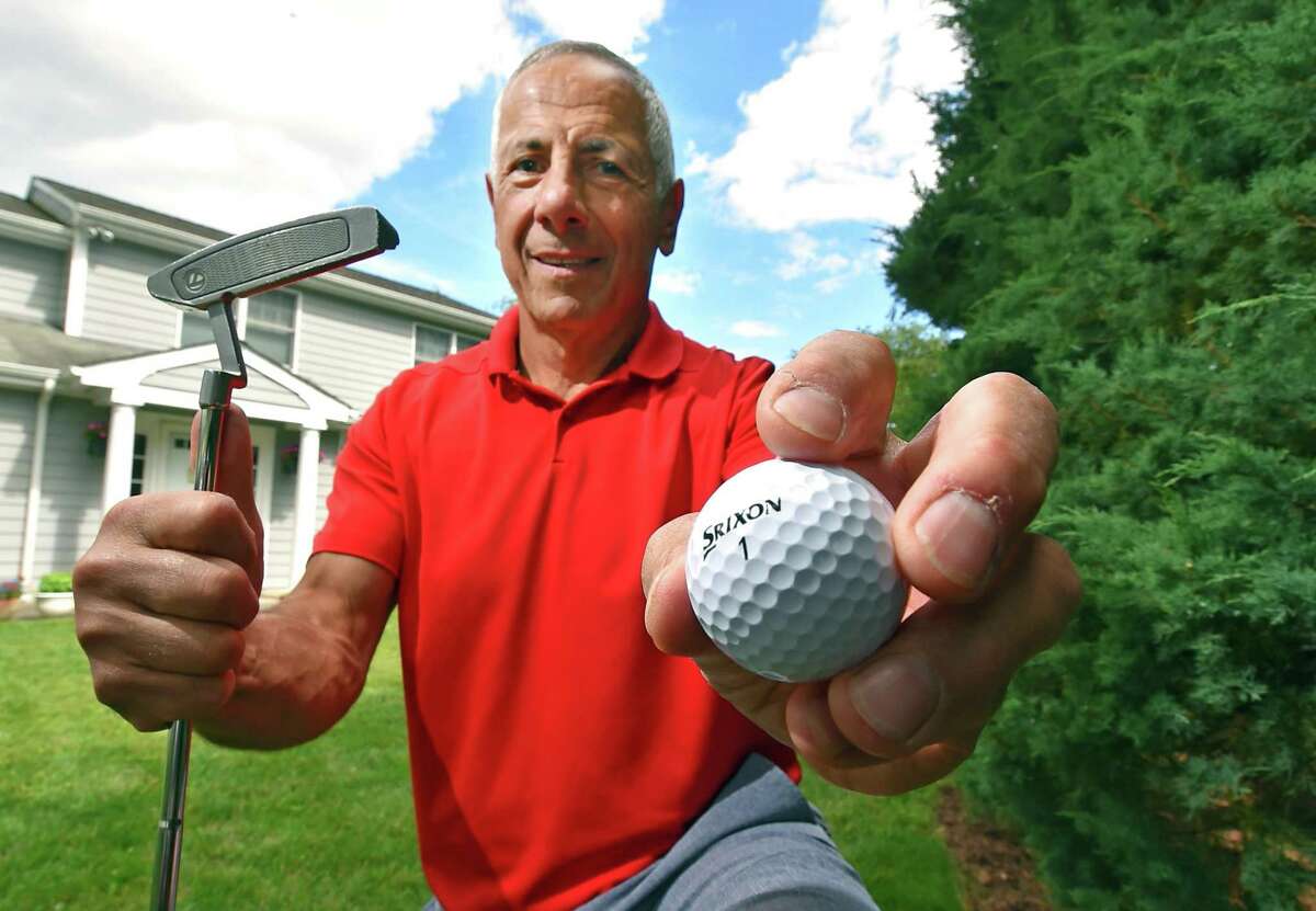 Peter Carino, who recently scored a hole in one at the town's municipal golf course, poses at his home in Greenwich, Conn., on Tuesday June 28, 2022. He did it on May 20 which was also the day his best friend Tom Conelias, who died suddenly in late April, had done in 2009. They even did it on the same hole, the seventh. The day is also significant because May 20 was the day before Conelias' father's funeral and the birthday of Conelias' late son who had been killed in a car accident when he was 10 years old. Carino felt this was a sign and will try to have the golf ball buried with his friend when the headstone is put in place.